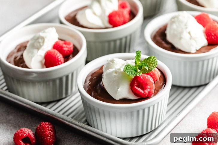 A tray of homemade pudding, topped with whipped cream and raspberries.