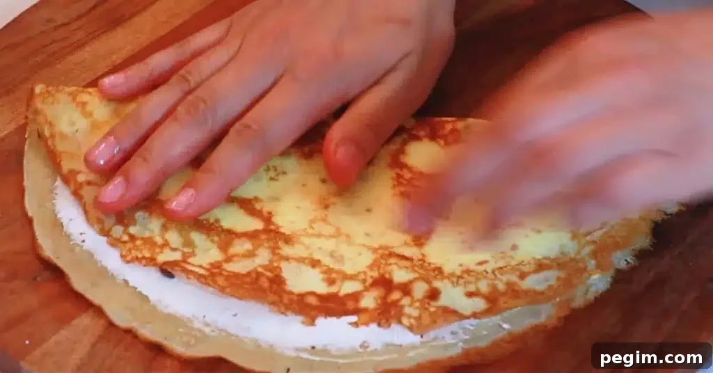 folding a crepe to make a crepe dessert