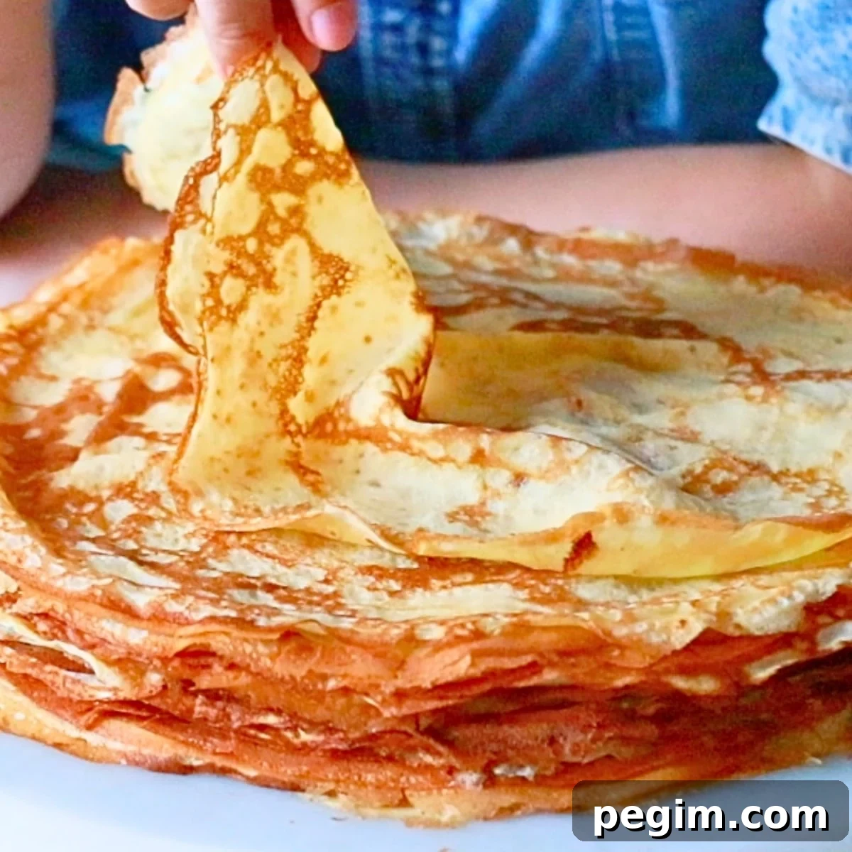 taking a piece of homemade crepe by hand