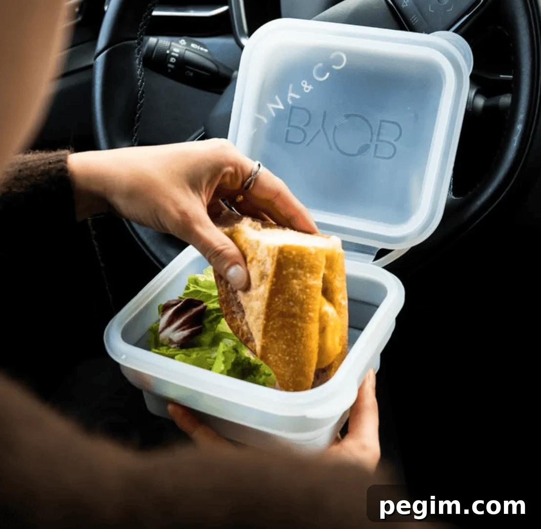 A collapsible silicone box from BYOB, filled with a sandwich inside.