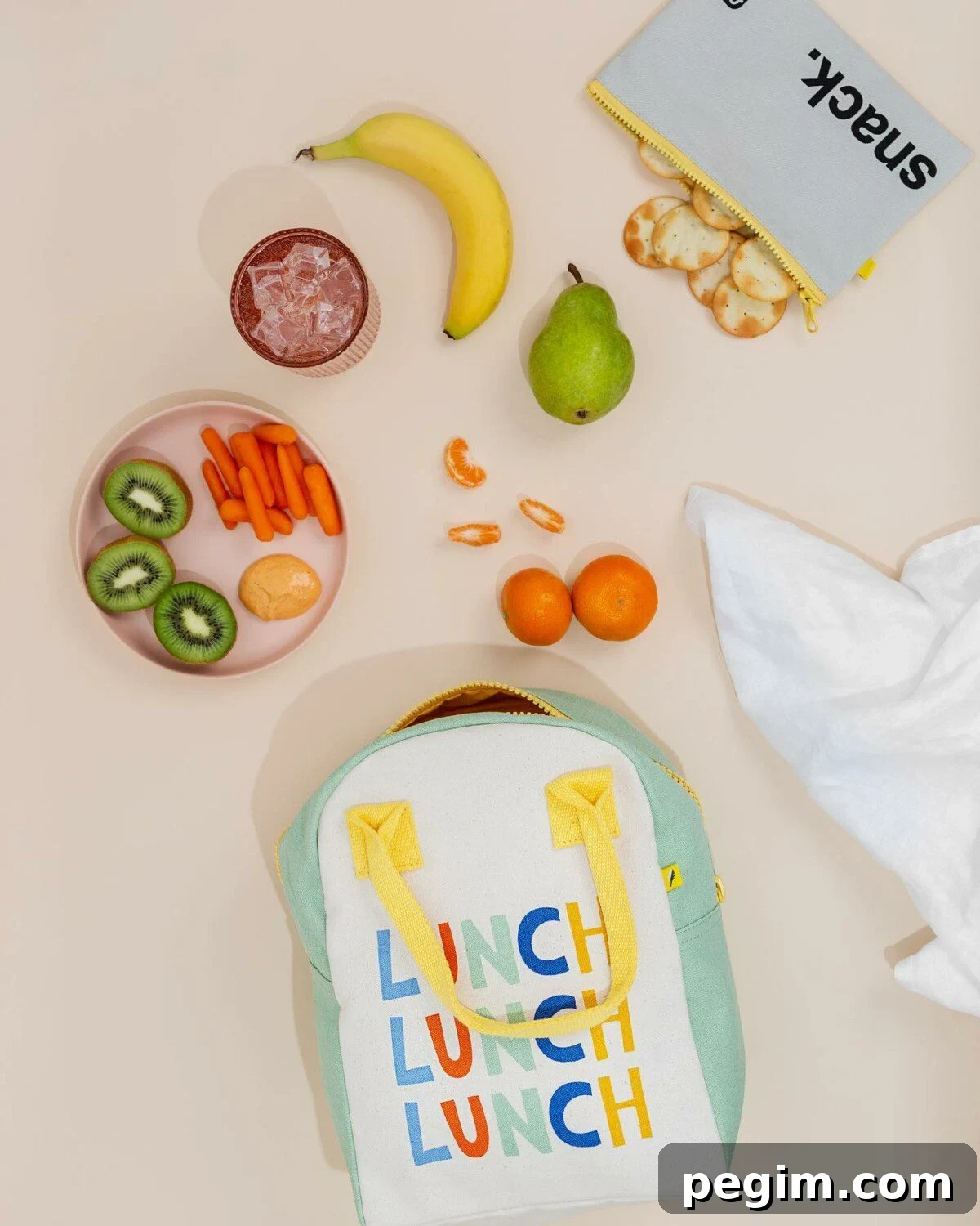Fluf's non-toxic kids' lunch box, with kiwis, carrot slices, bananas, oranges, and biscuits alongside it