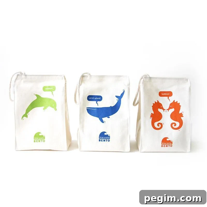 Three machine-washable lunchboxes from ECOlunchbox crafted from organic cotton, featuring eco-friendly ink-printed sea animals, beautifully lined up.