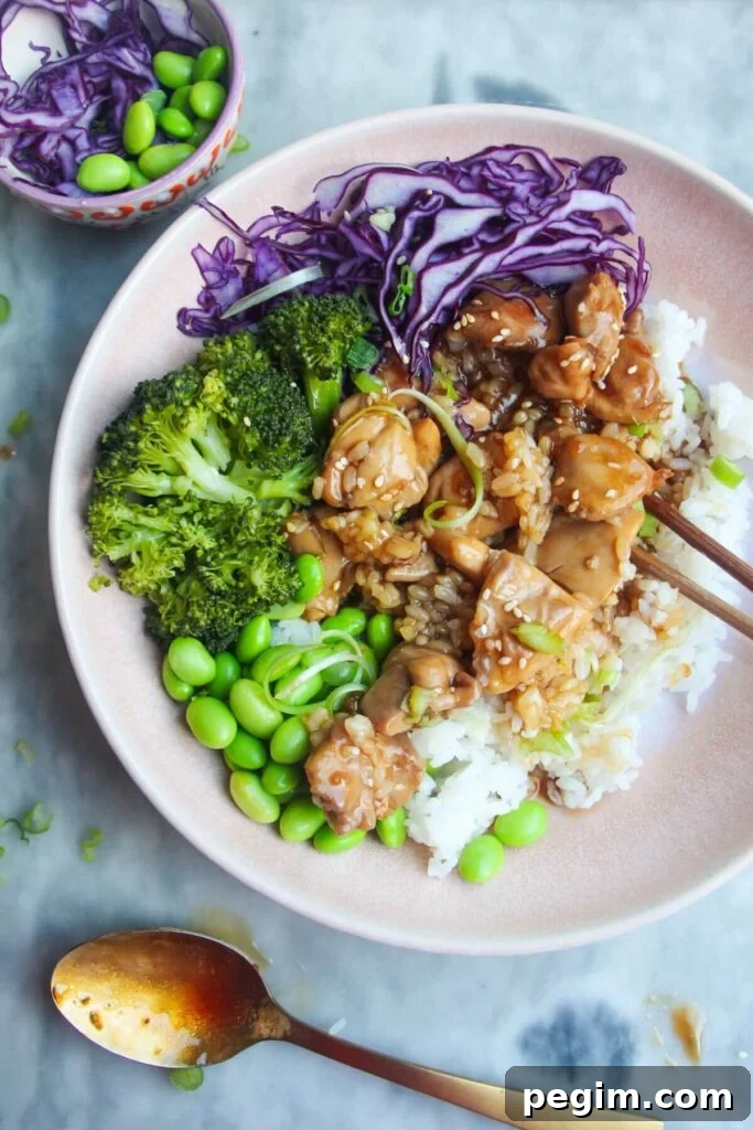 Glossy chicken teriyaki on top of rice with red cabbage, edamame and broccoli.