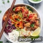 Grilled chicken poke bowl on a grey marble background.
