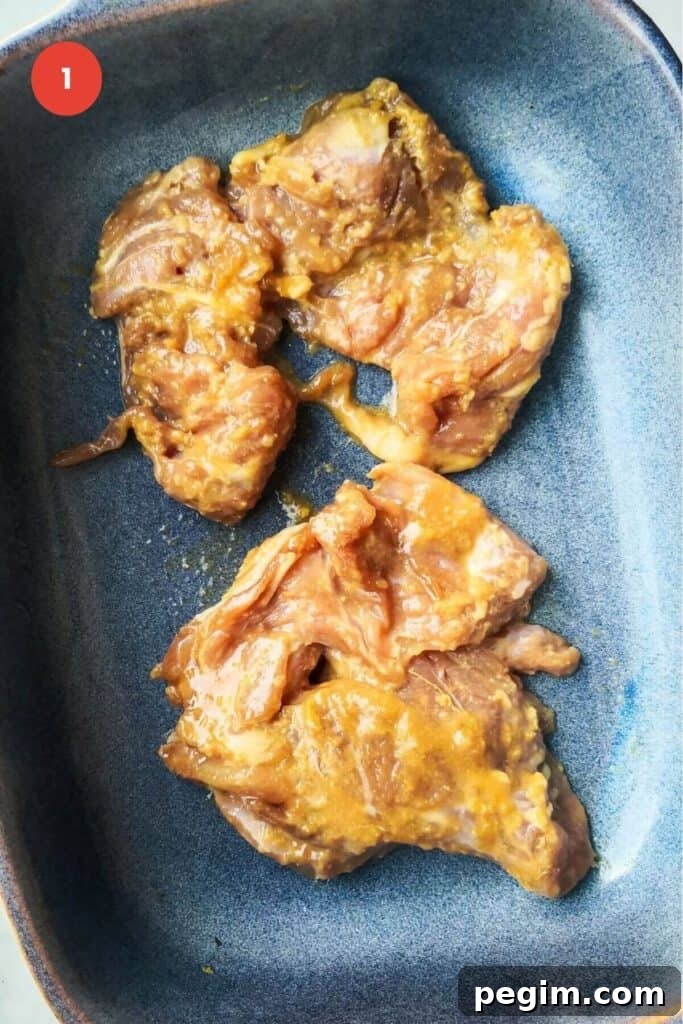 Marinated chicken thighs in a baking dish.