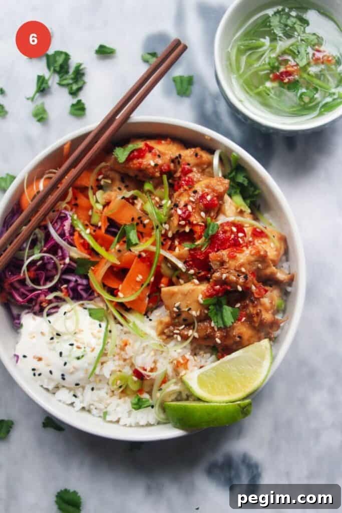 Chicken poke bowl with chopsticks and lime wedge on the side.