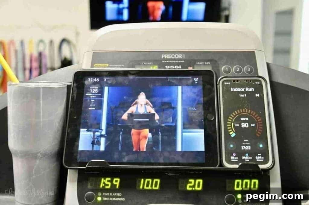 iPad playing a peloton tread workout, sitting on a treadmill.