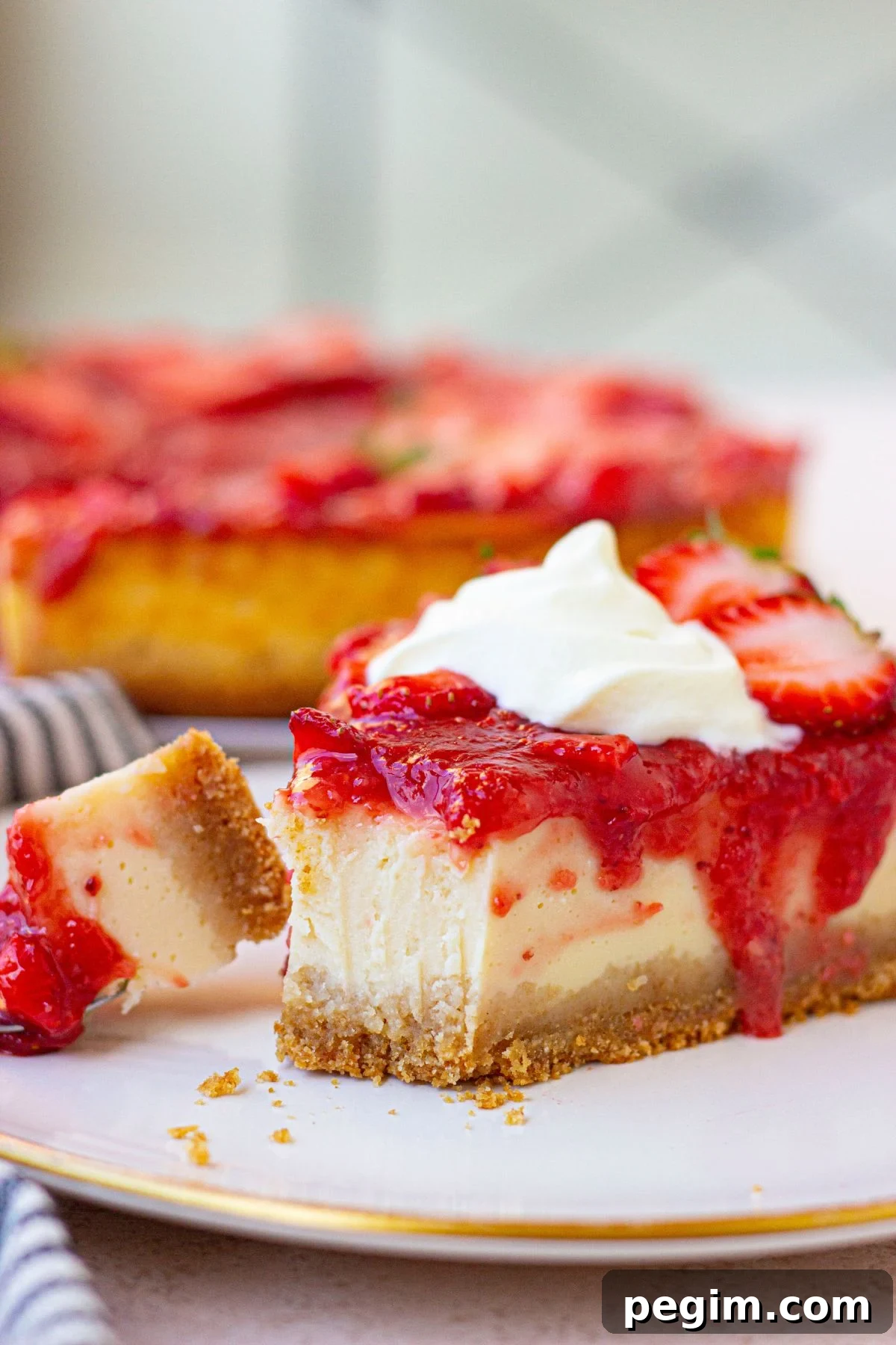 Protein cheesecake topped with strawberries topping on a white plate.