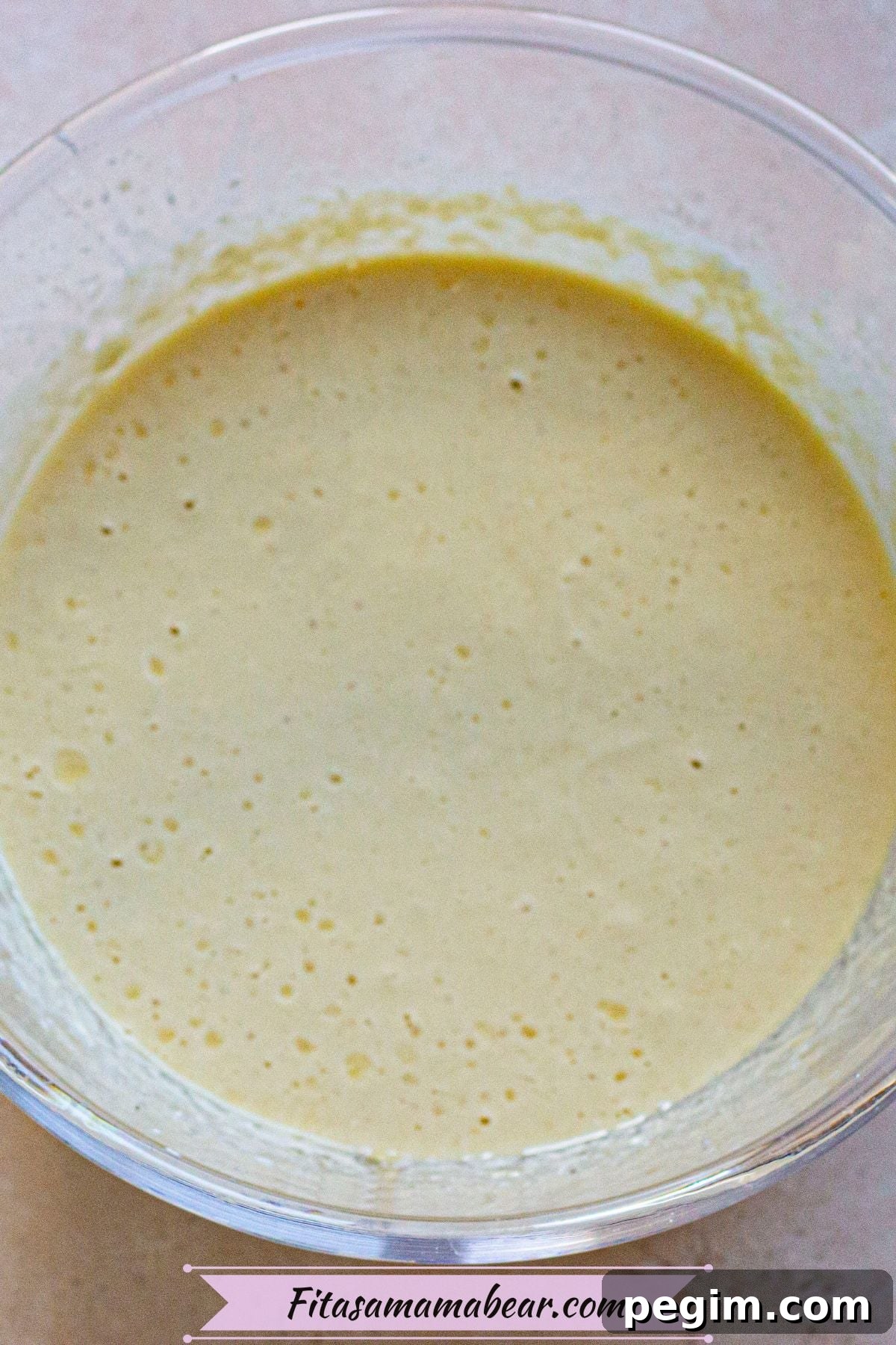 Raw cheesecake filling in a glass bowl.