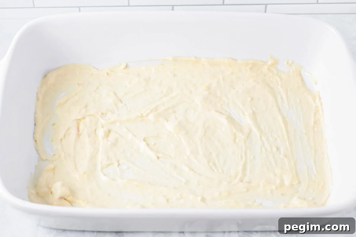 Spreading the chicken mixture in the bottom of a baking dish.