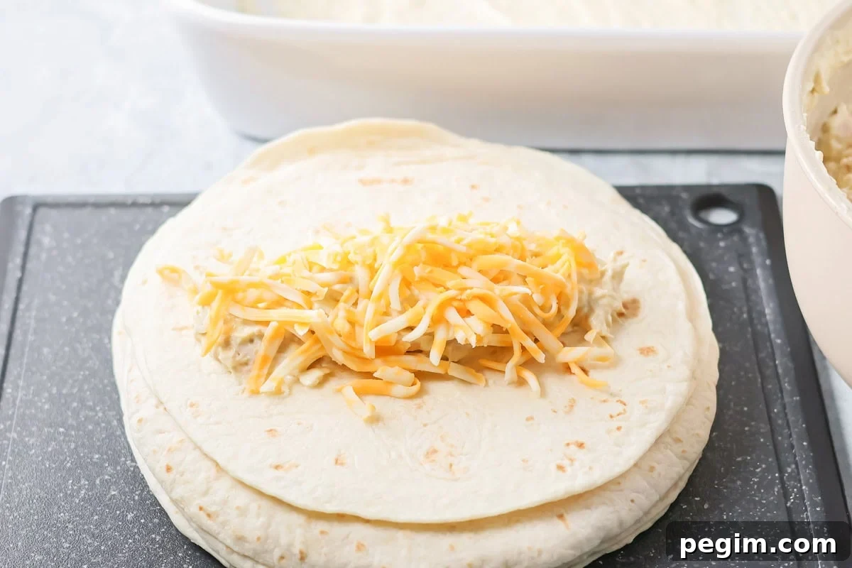 Filling tortillas with chicken and cheese.
