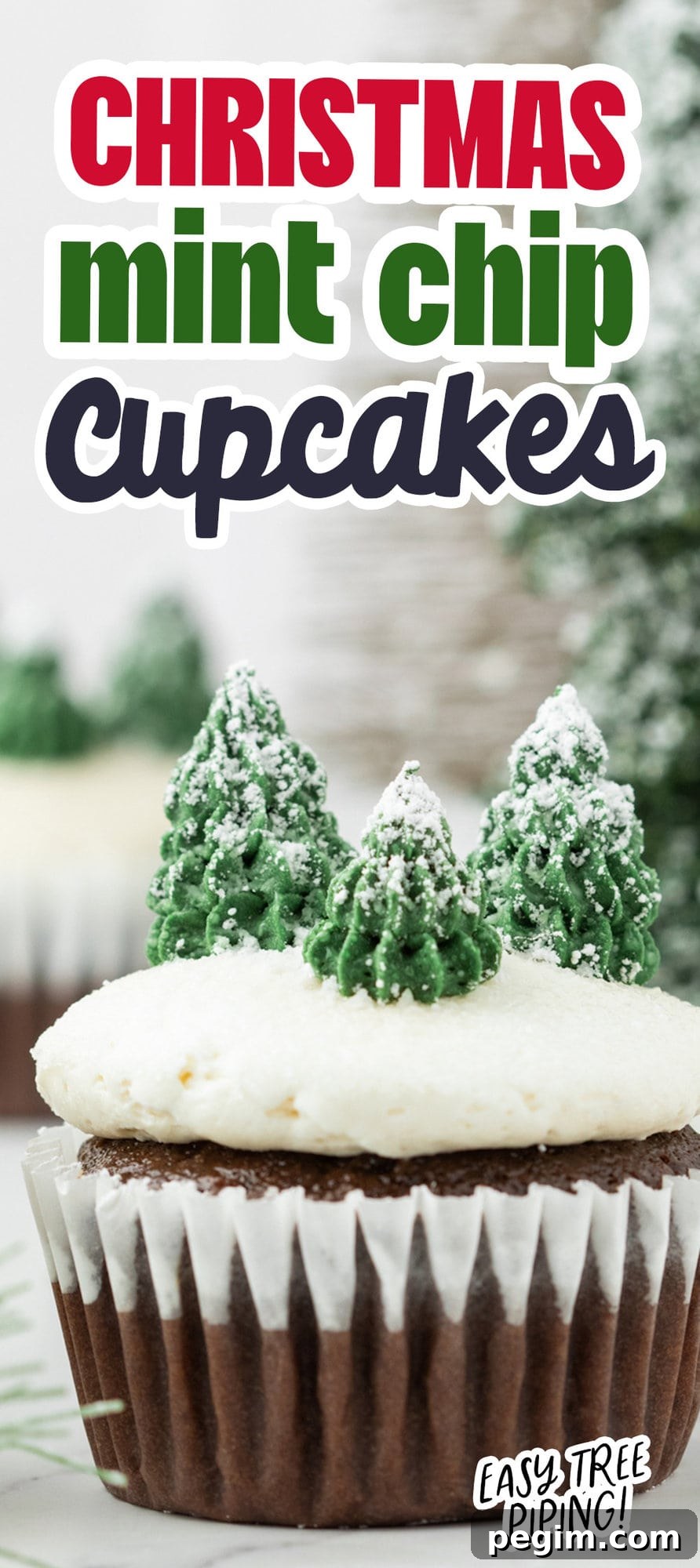 picture of mint chocolate cupcake with buttercream icing, powdered sugar snow, and buttercream piped trees on top on a plate