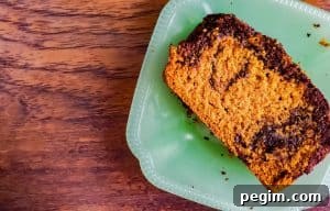 A close up shot of the pumpkin bread on a glass teal plate. The plate is sitting on a wooden surface.