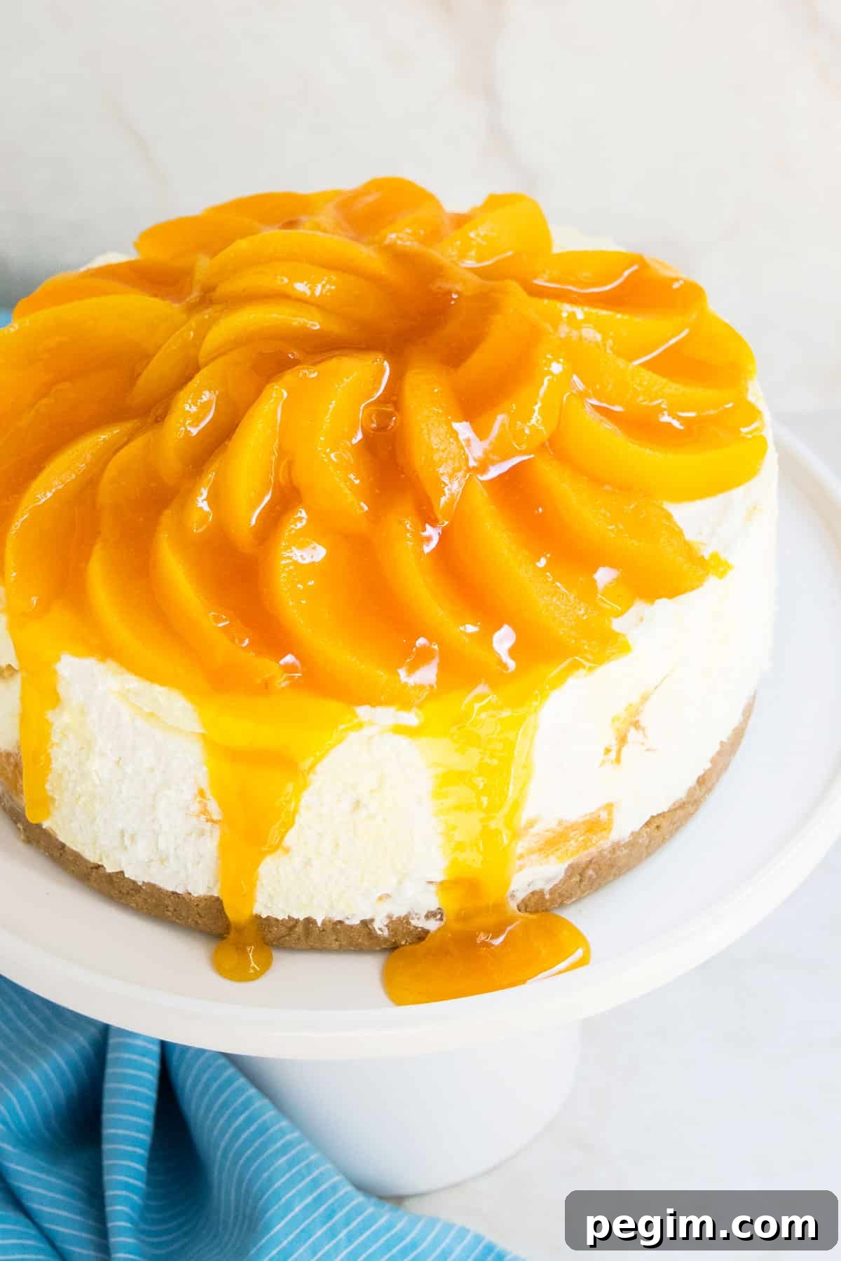 Easy No Bake Peach Cheesecake With Fresh or Canned Peaches and Graham Cracker Crust on White Cake Stand.