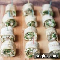 Easy Chicken Caesar Salad Pinwheels with toothpicks lined up on a cutting board