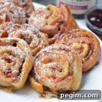 Monte Cristo Pinwheels laid out on a plate and dusted with powered sugar