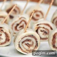 Garlic Roast Beef Pinwheels with toothpicks arranged on a palte