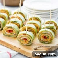 Roasted Red Pepper Hummus Pinwheels with toothpicks lined up on a cutting board