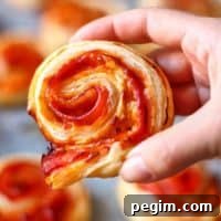 hand holding a Bacon Pinwheel with Cheddar