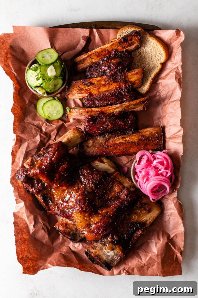 easy smoked beef back ribs on peach butcher paper with bread, pickles and pickled red onions