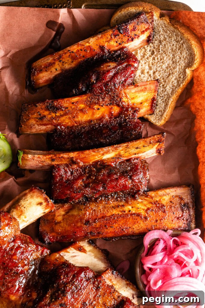 easy smoked beef back ribs on peach butcher paper with bread, pickles and pickled red onions