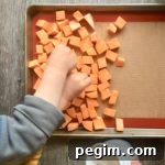 little kids seasoning cubed sweet potatoes in a pan with salt