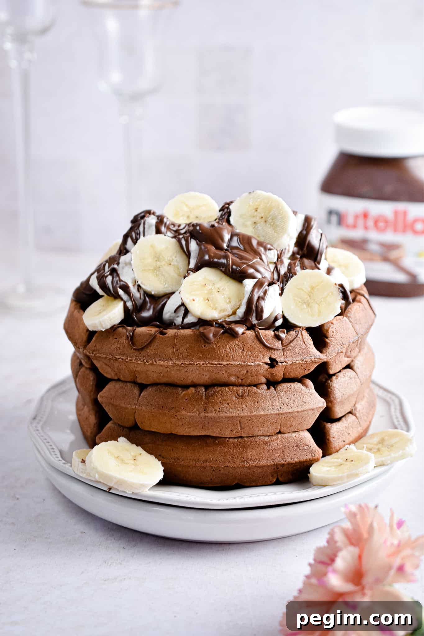 The Nutella waffles are topped with whipped cream and bananas.