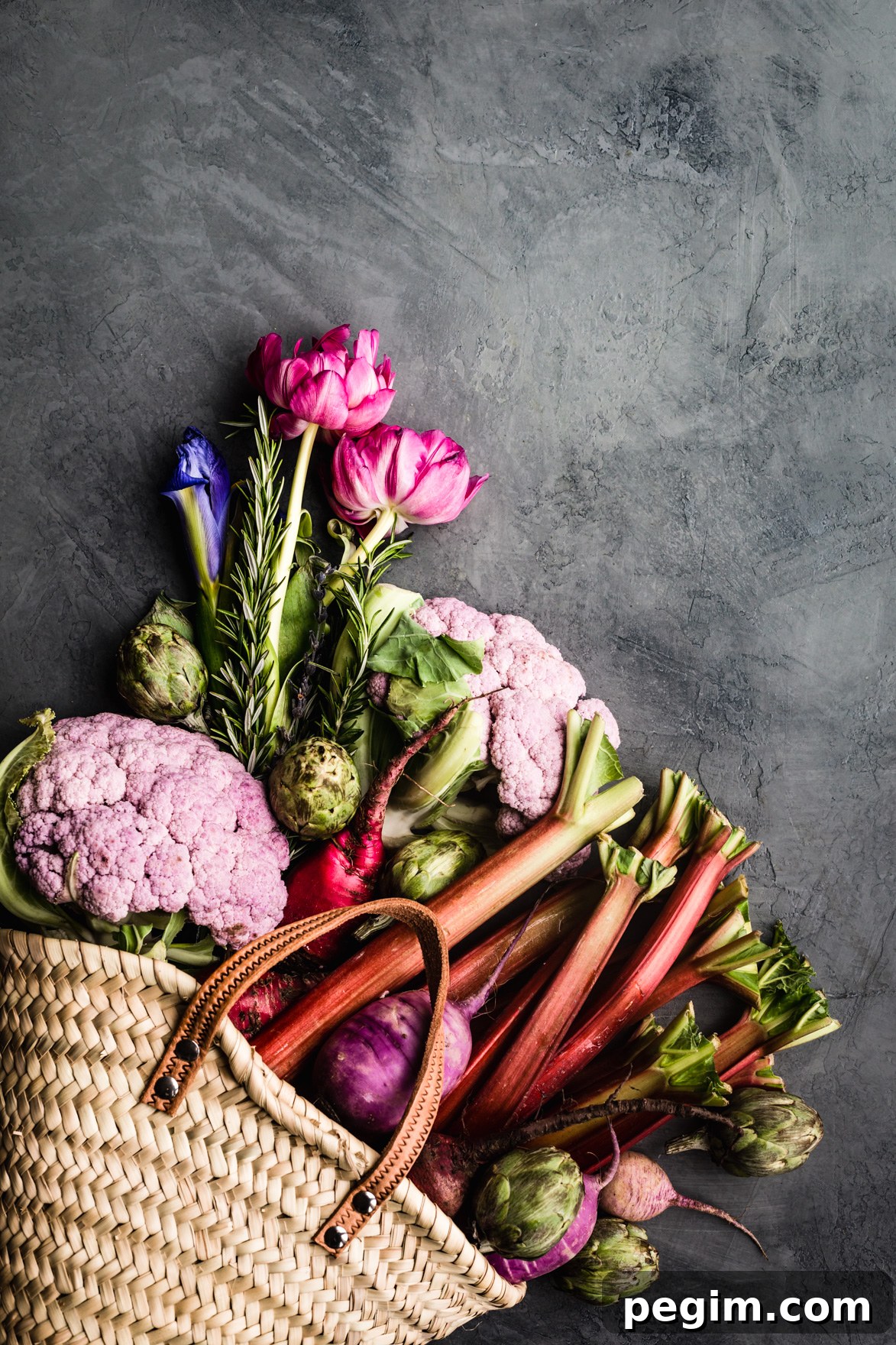 Early summer farmers market bounty haul of purple cauliflower, artichokes, radishes, beets, rhubarb and rosemary.