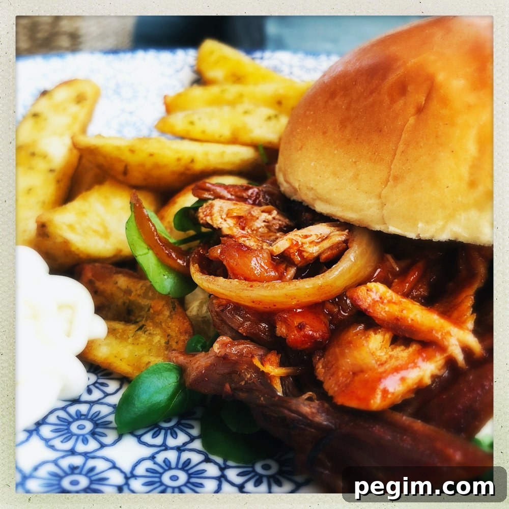 slow cooker pulled pork with peppers and onions in a BBQ marinade served with watercress salad on a toasted brioche bun. Pile of potato wedges and soured cream dip on the side.