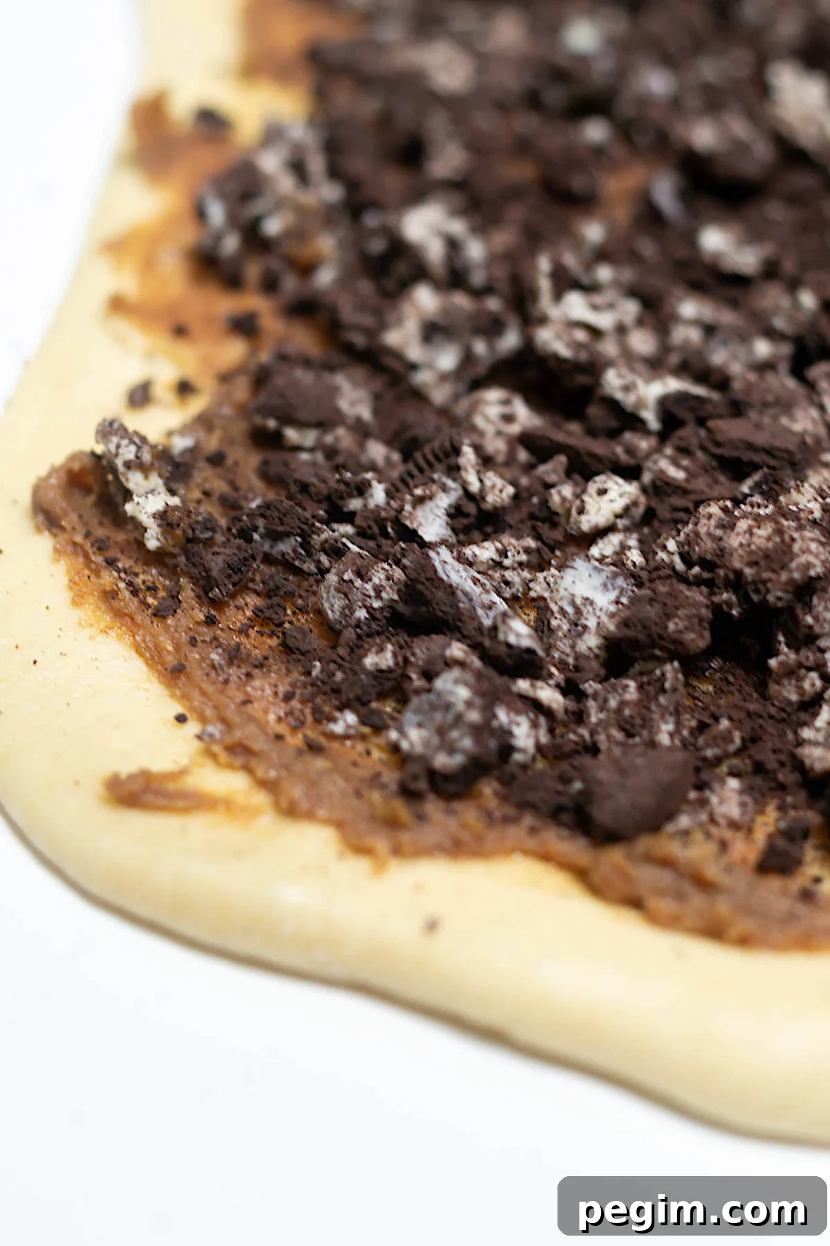 oreo cookies crumbled over the top of the cinnamon roll filling