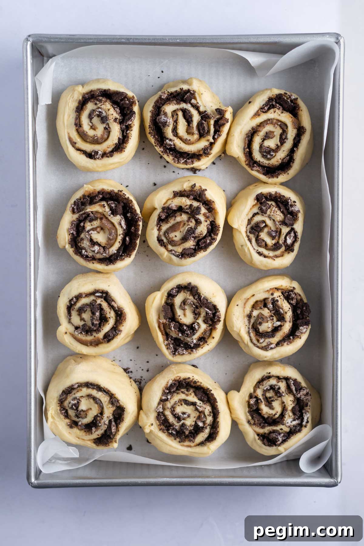 oreo cinnamon rolls in a parchment lined baking pan