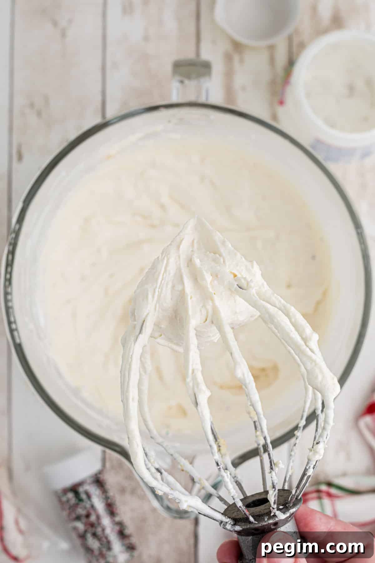 Close up of a wire whisk that has mixed up Christmas Tree Dip.