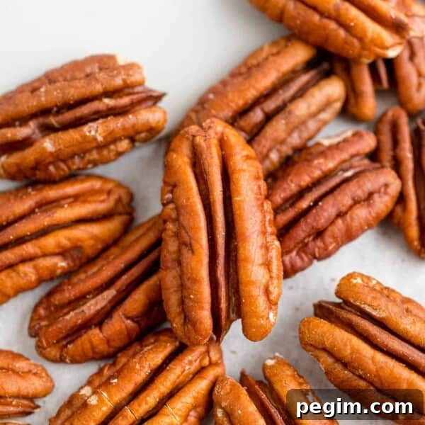How to toasted pecans post image, pecan halves and a spatula.