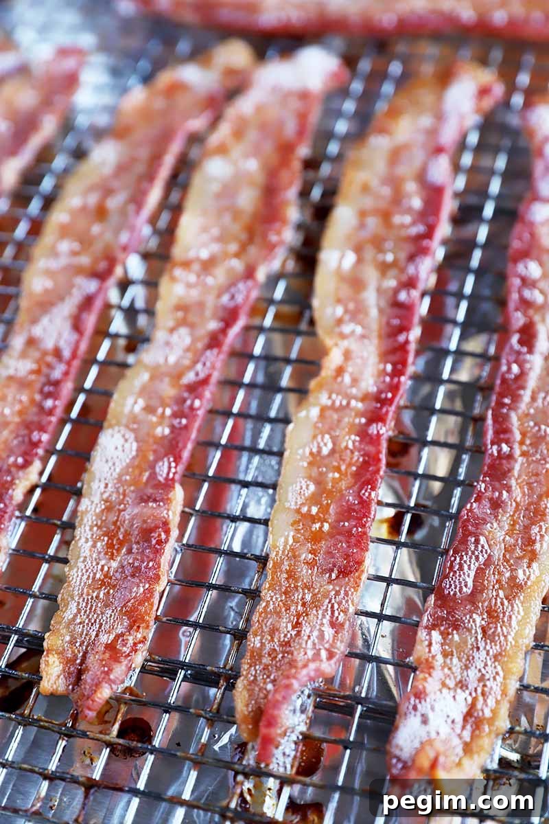 Vertical image of cooked sliced breakfast meat on a cooling rack.