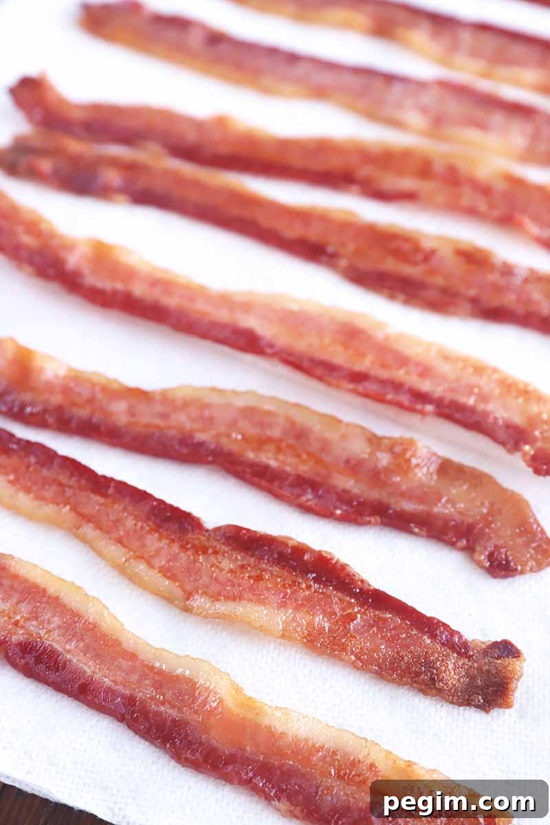 Vertical image of slices of cooked breakfast meat draining on paper towels.