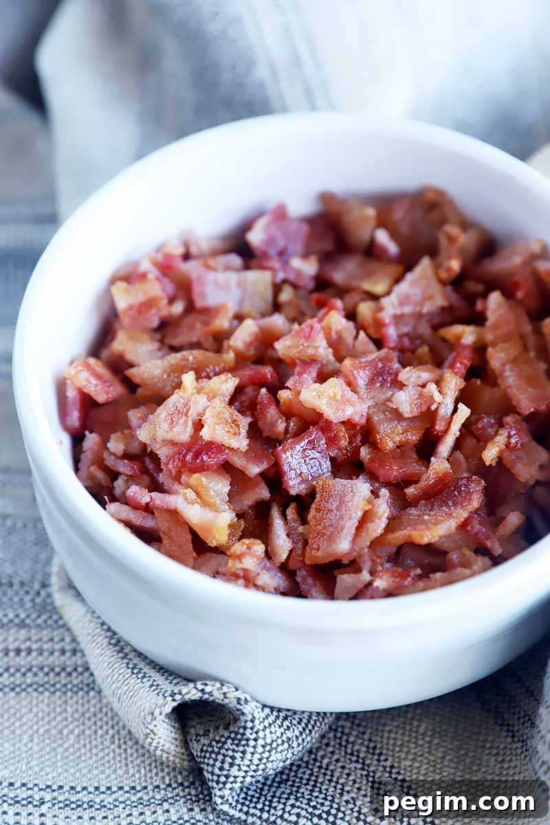 Vertical image of a white bowl filled with chopped thin pieces of meat.