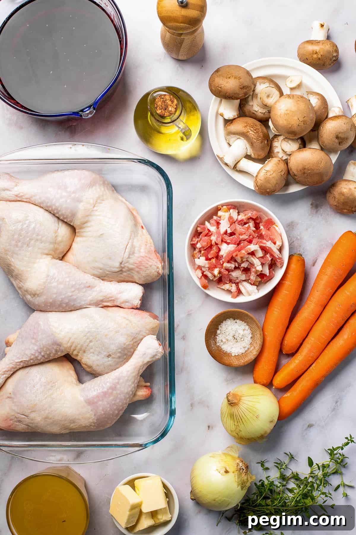 Clockwise from top: Black pepper, mushrooms, carrots, bacon, salt, onions, fresh thyme, butter, chicken leg quarters, red wine.