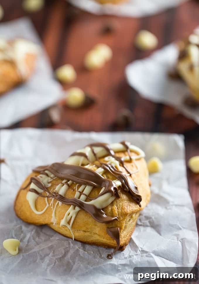 Heart-Shaped Nutella Cookies Recipe for Valentine's Day 2 Nutella Hearts - Smooth, creamy Nutella nestled inside a buttery heart-shaped croissant with drizzled milk and white chocolate on top. This Valentine's Day dessert is sublime!