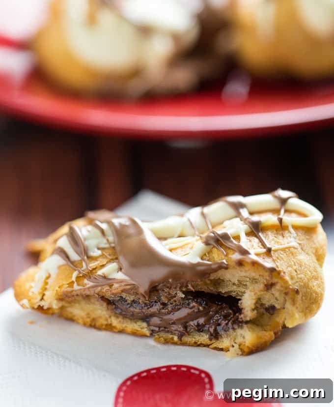 Heart-Shaped Nutella Cookies Recipe for Valentine's Day 5 Nutella Hearts - Smooth, creamy Nutella nestled inside a buttery heart-shaped croissant with drizzled milk and white chocolate on top. This Valentine's Day dessert is sublime!