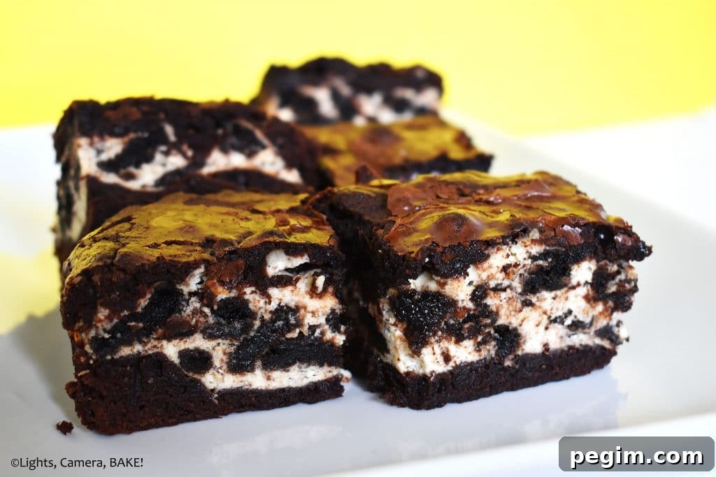 Cookies and Cream Cheesecake Brownies Recipe 16 Cookies and cream cheesecake filled brownies on a plate.