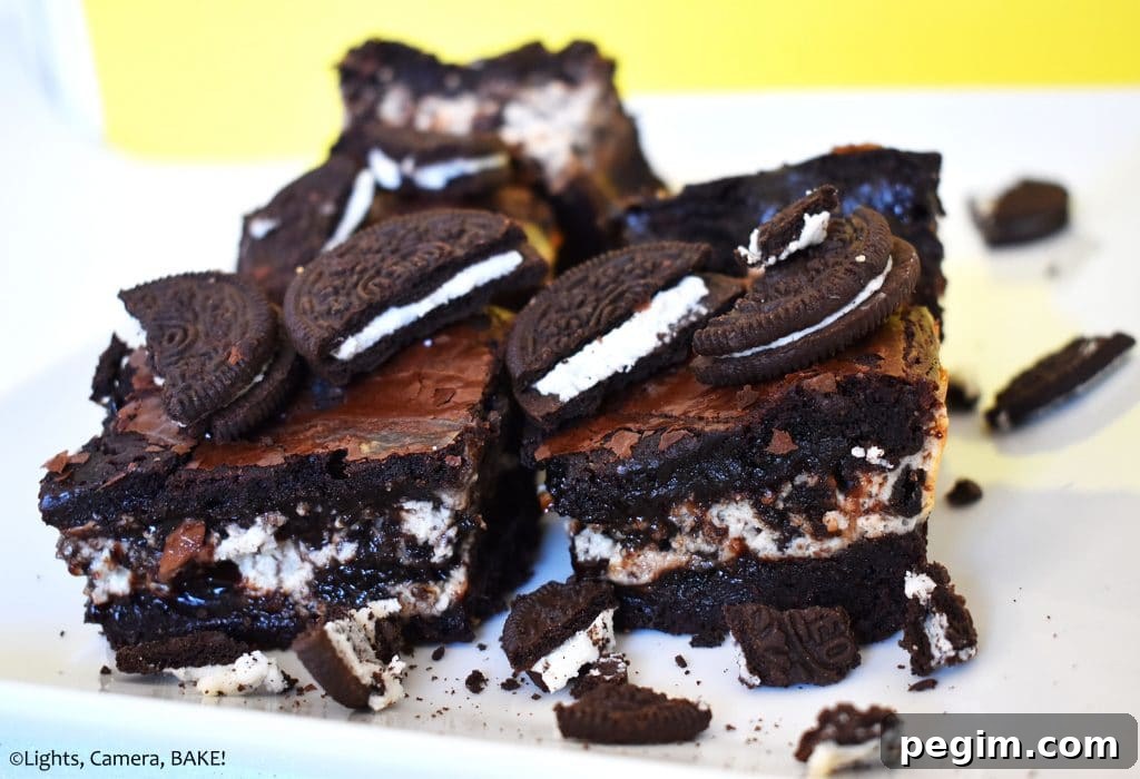 Cookies and Cream Cheesecake Brownies Recipe 3 Oreo cheesecake brownies on a plate.