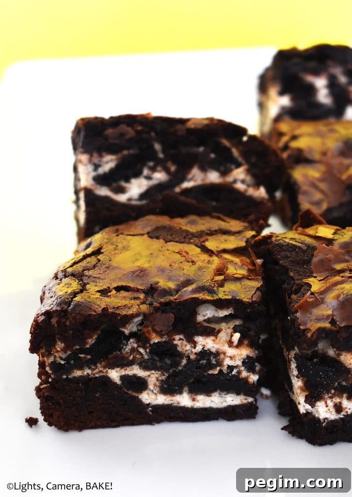 Cookies and Cream Cheesecake Brownies Recipe 5 Cookies and cream cheesecake filled brownies on a plate.