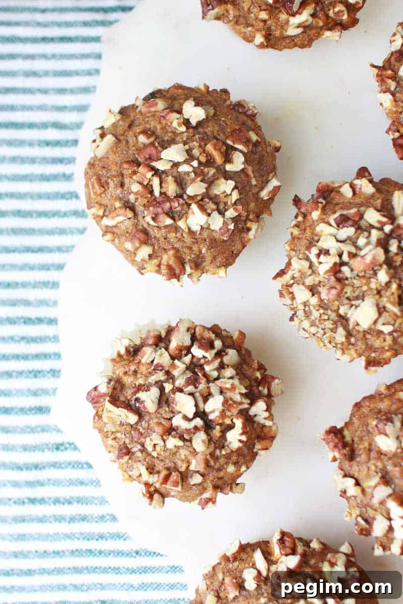 Whole Wheat Banana Nut Muffins Recipe 6 banana nut muffins set on a marble cutting board