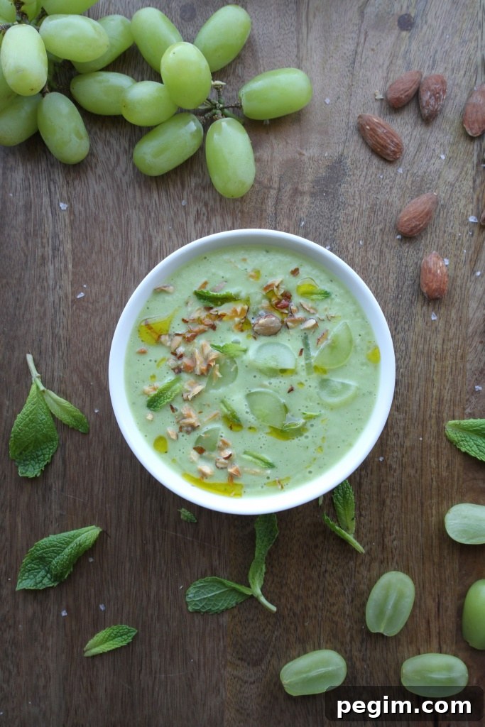 Chilled Green Gazpacho with Grapes and Toasted Almonds 2 Green gazpacho served in bowls with grapes and mint garnish