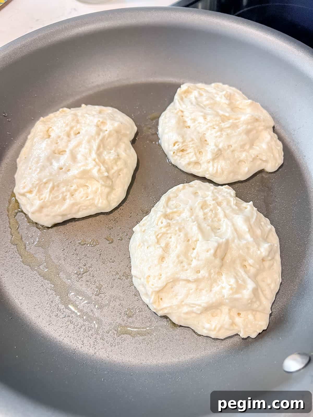 Fluffy Greek Yogurt Pancakes That Stay Light and Tender 7 Greek yogurt pancakes before flipping on a pan.