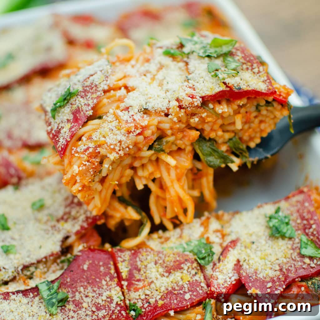 Sun-Dried Tomato & Roasted Pepper Pasta Recipe for Quick Weeknights 5 Picking up a slice of our Sundried Tomato and Roasted Pepper Pasta with a black spatula