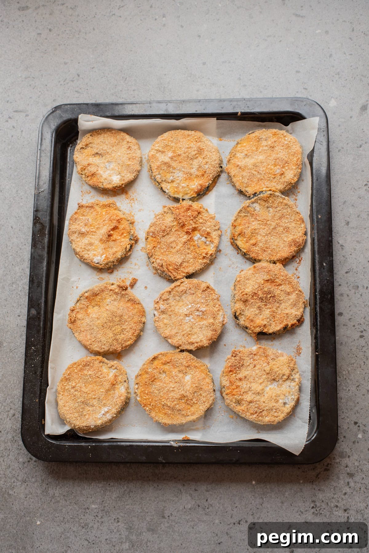 Crispy Baked Eggplant Parmesan Recipe 6 An overhead image of the eggplant slices arranged on a baking sheet.