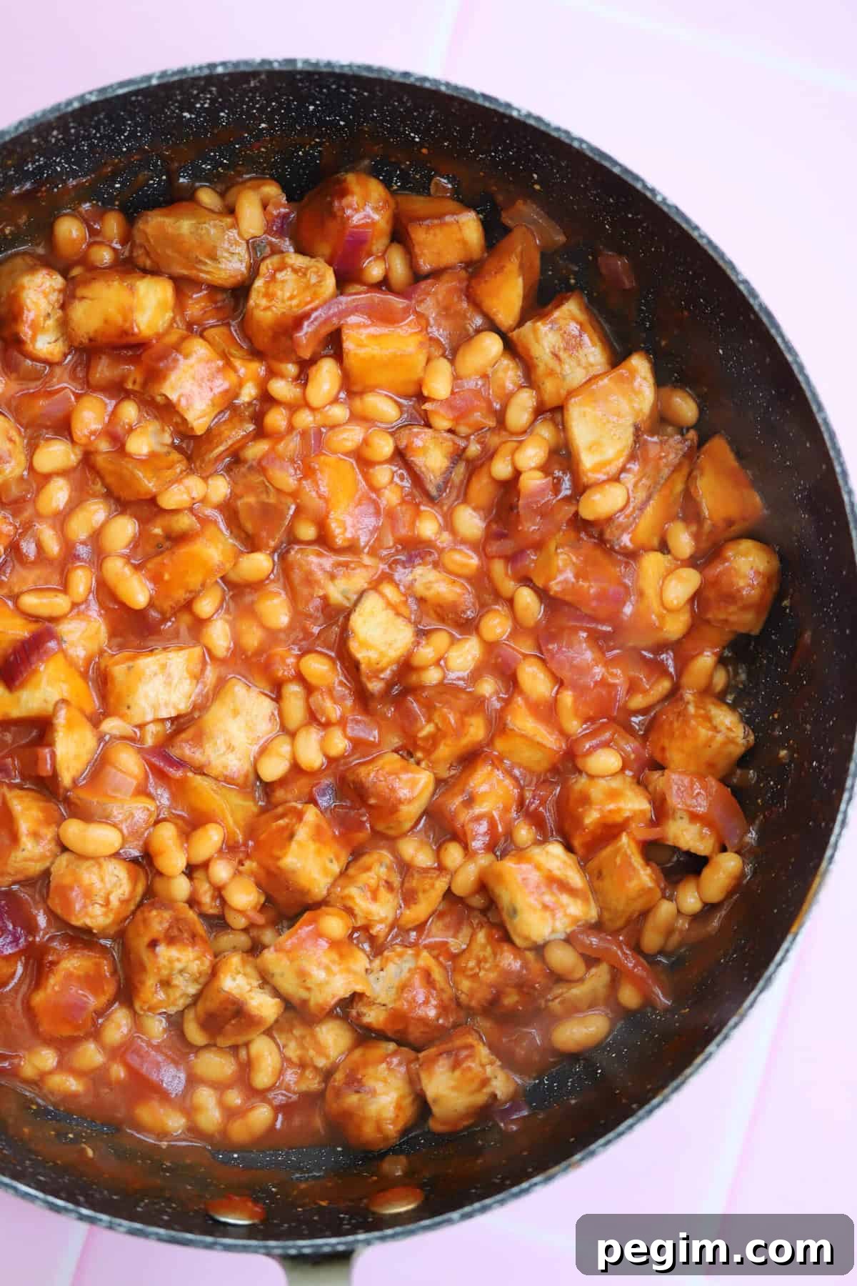 Hearty One-Pan Breakfast Bowl with Eggs and Veggies 9 A pan of chicken sausage pieces, beans and potatoes.