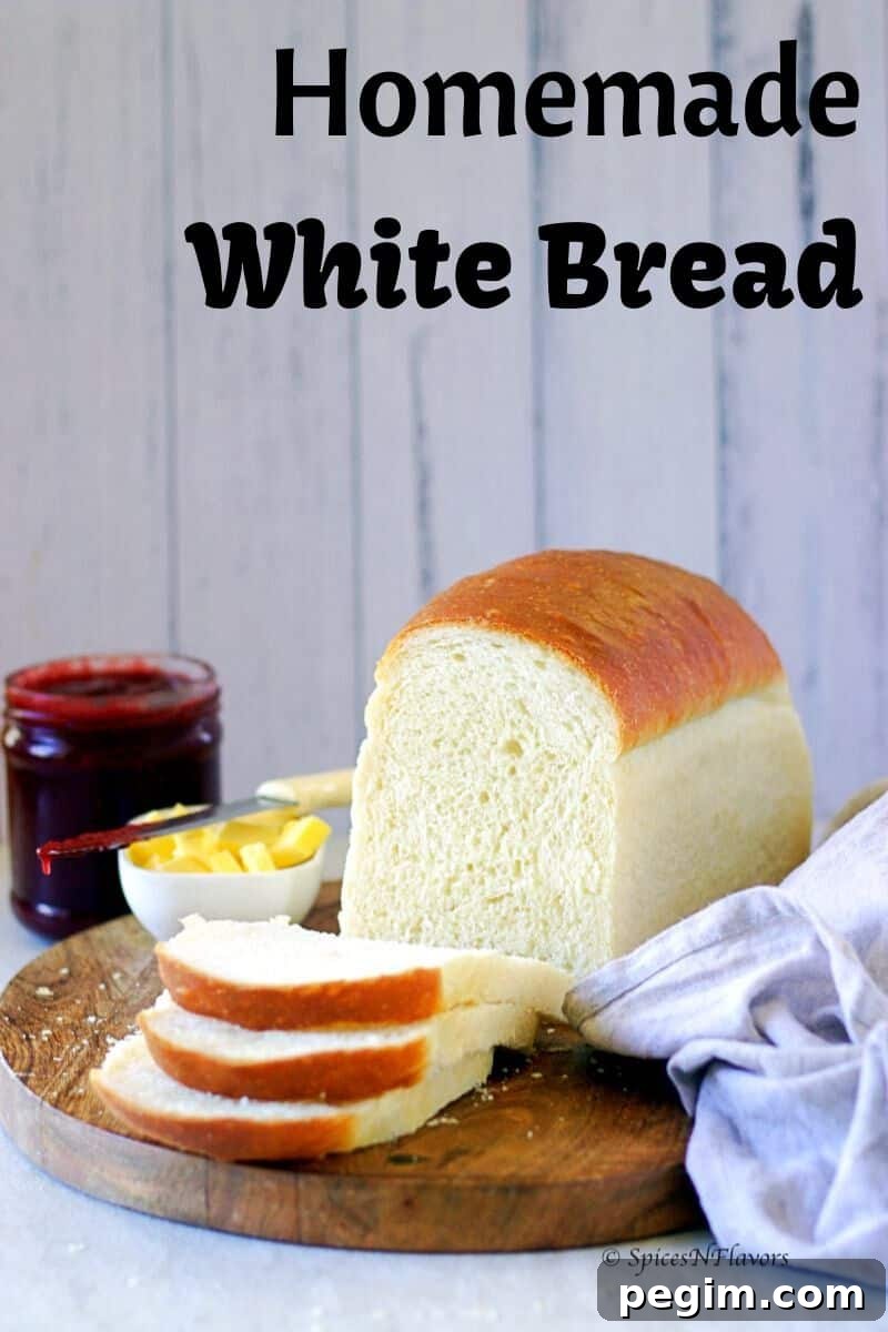 Bake Homemade White Bread in 5 Simple Steps 2 Loaf of bread placed on a wooden board with two cut slices showing the bread texture