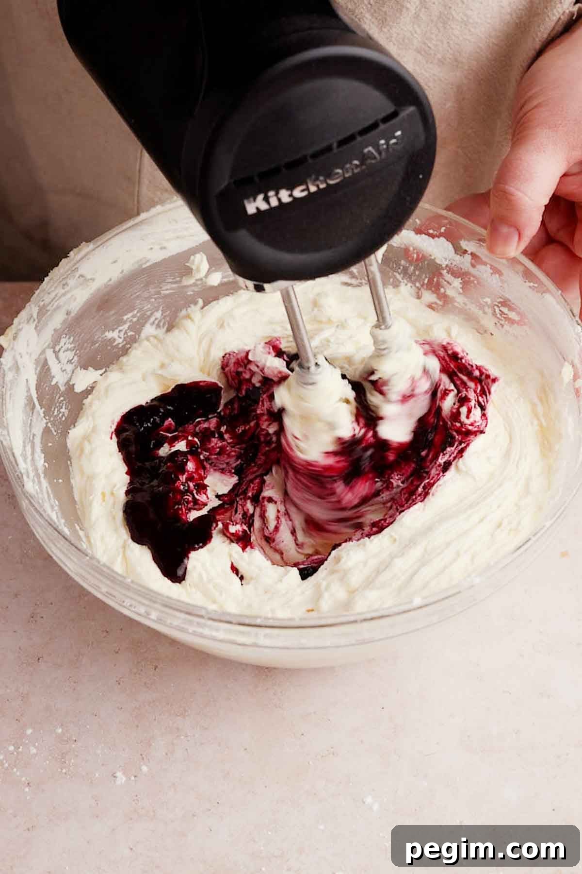 Blueberry Birthday Cake Recipe — Moist Layer Cake for Parties 11 adding blueberry filling into frosting to make it purple